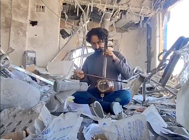 Conmueve músico iraní tocando entre los escombros de una escuela en Teherán